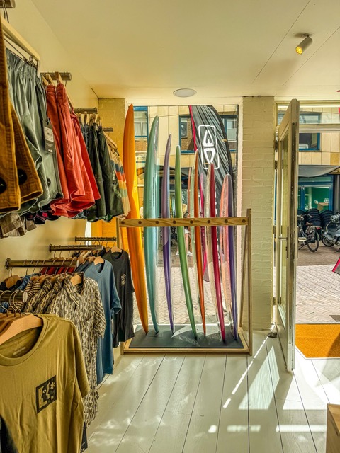 Kleurrijke surfboards en kleding in de shop